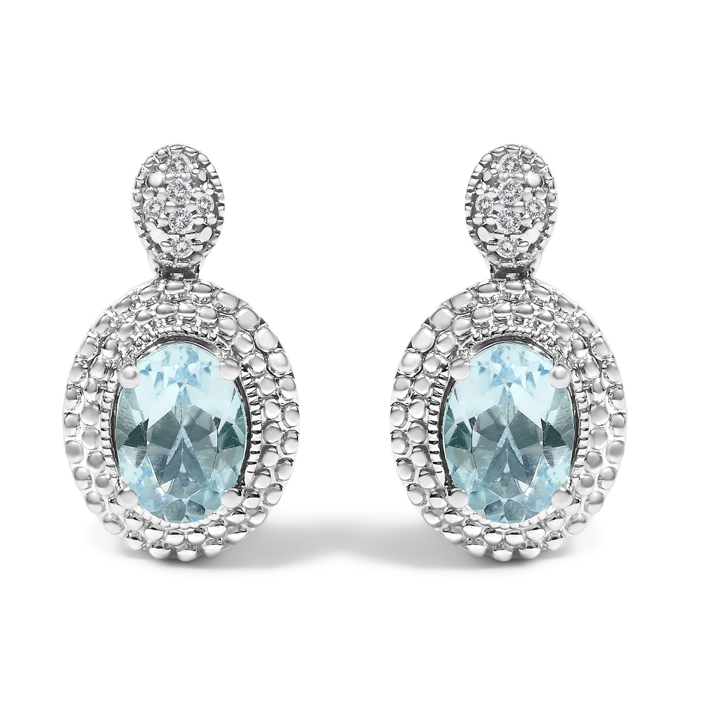 Front view of a pair of white metal earrings with oval blue gemstones set in the center, surrounded by pave-set round white gemstones, shown against a white background.