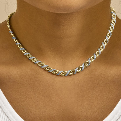 Close-up front view of a yellow metal necklace with alternating chain links featuring white round gemstones in prong settings, worn on a model.