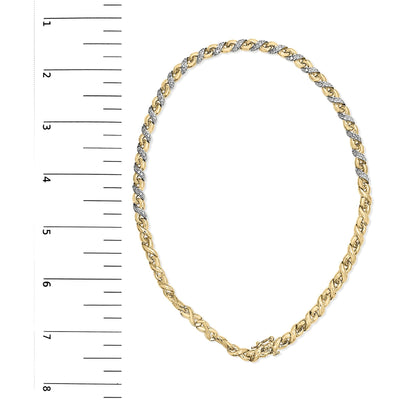 Top-down view of yellow metal necklace with alternating sections of white gemstones in prong settings, displayed on a ruler for size reference.
