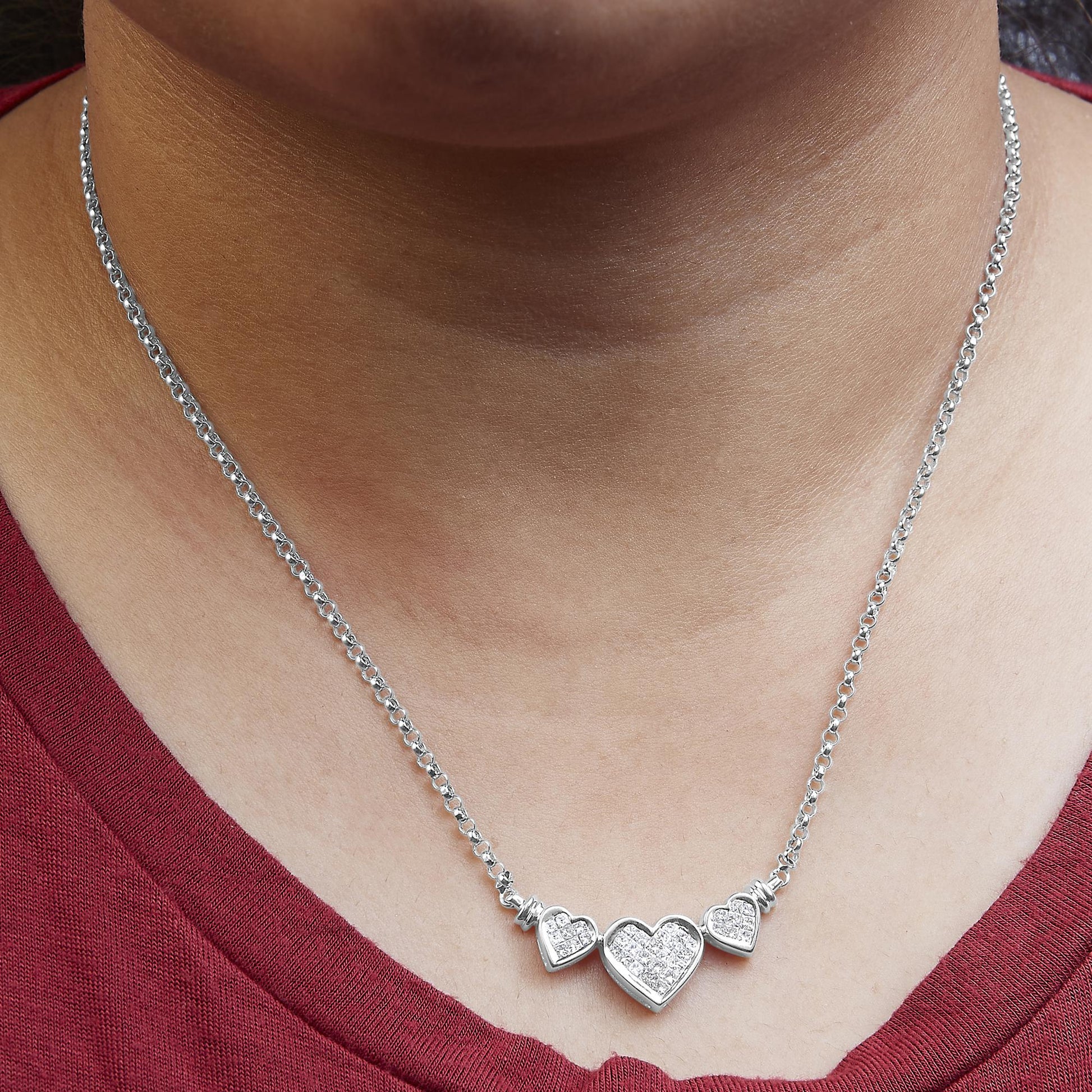 White metal necklace with three heart-shaped pendants featuring white gemstones, worn on a model, front-facing angle.