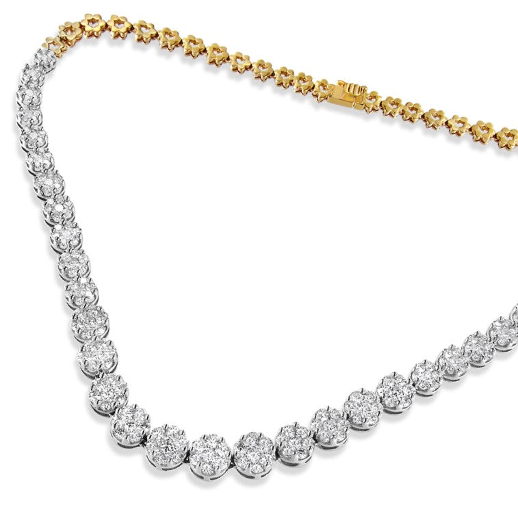 Close-up angled shot of a yellow necklace featuring round white gemstones in a pave setting along one side and floral-shaped yellow metal links on the other side.