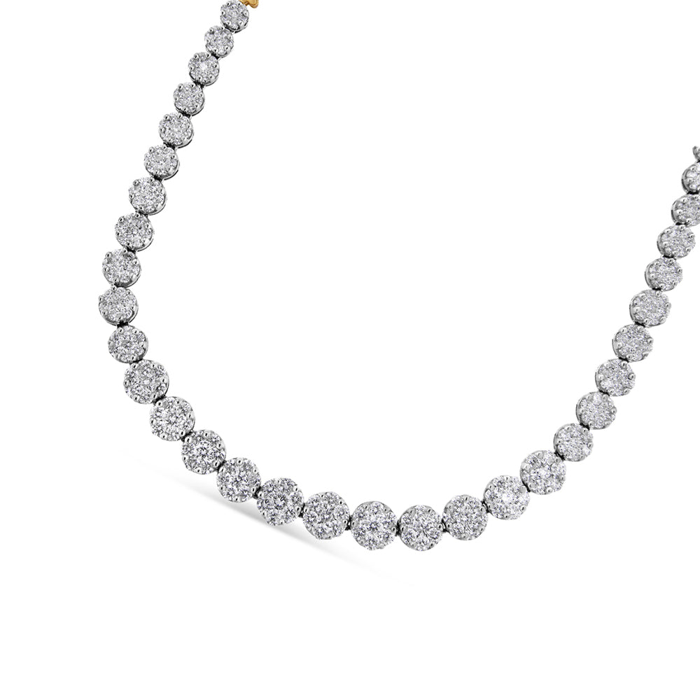 Close-up angled view of a yellow metal necklace featuring round-shaped clusters with white gemstones in pave setting.