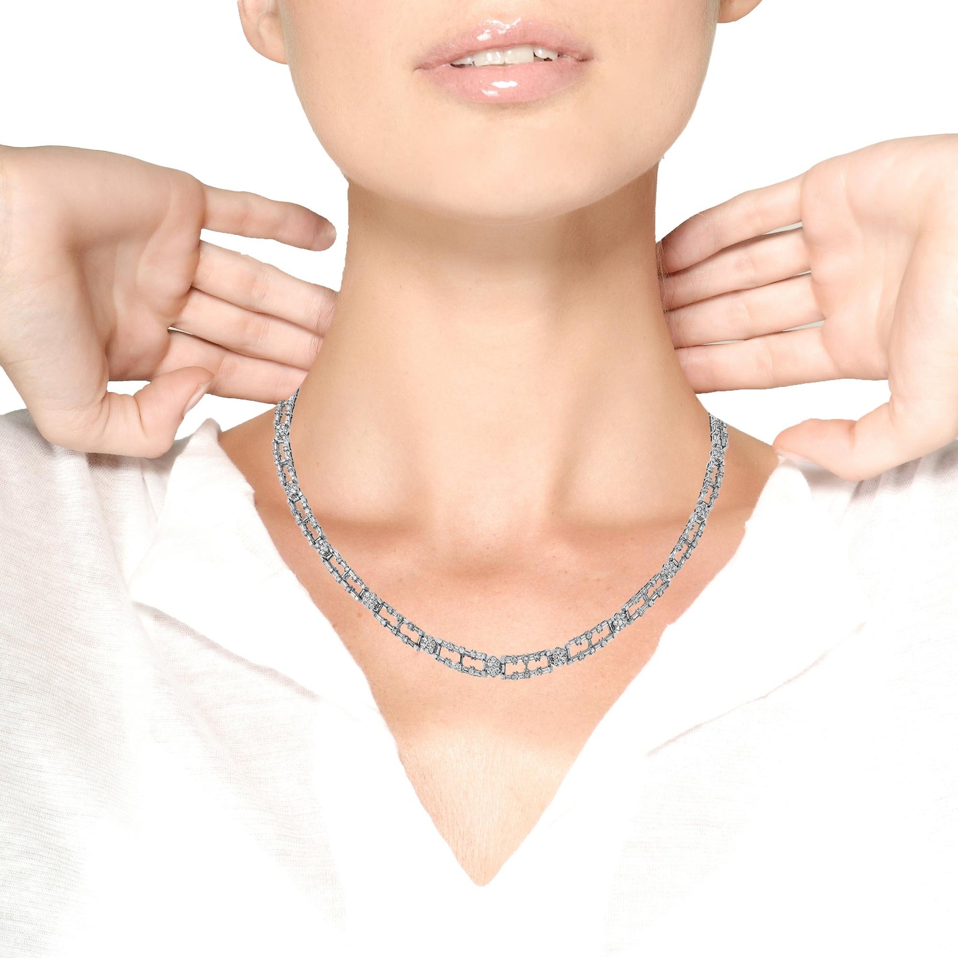 White metal necklace with alternating sections of baguette and round white gemstones, worn on a model, front view.