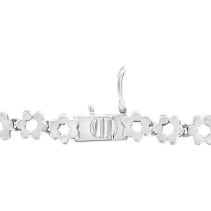 Close-up image of a white metal necklace clasp with flower-shaped links, shown from the top angle.
