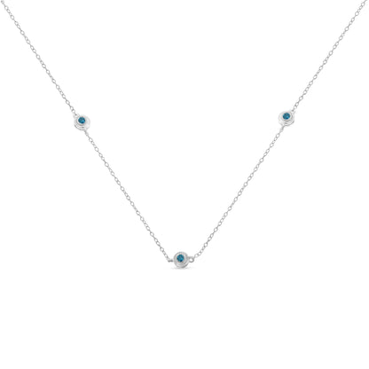 Front-facing view of a white necklace with a delicate chain featuring three round blue gemstones set in bezel settings evenly spaced along the chain.