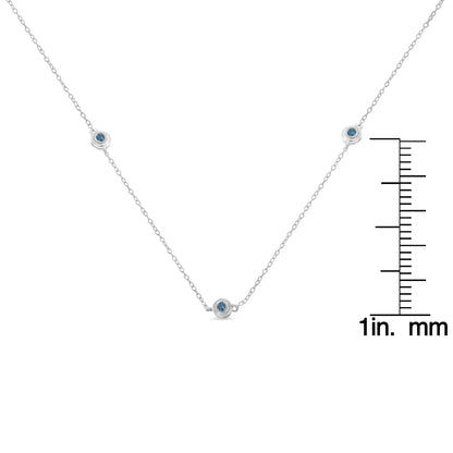Close-up front angle of a white necklace with multiple round blue gemstones in bezel settings, shown with a ruler for size reference.