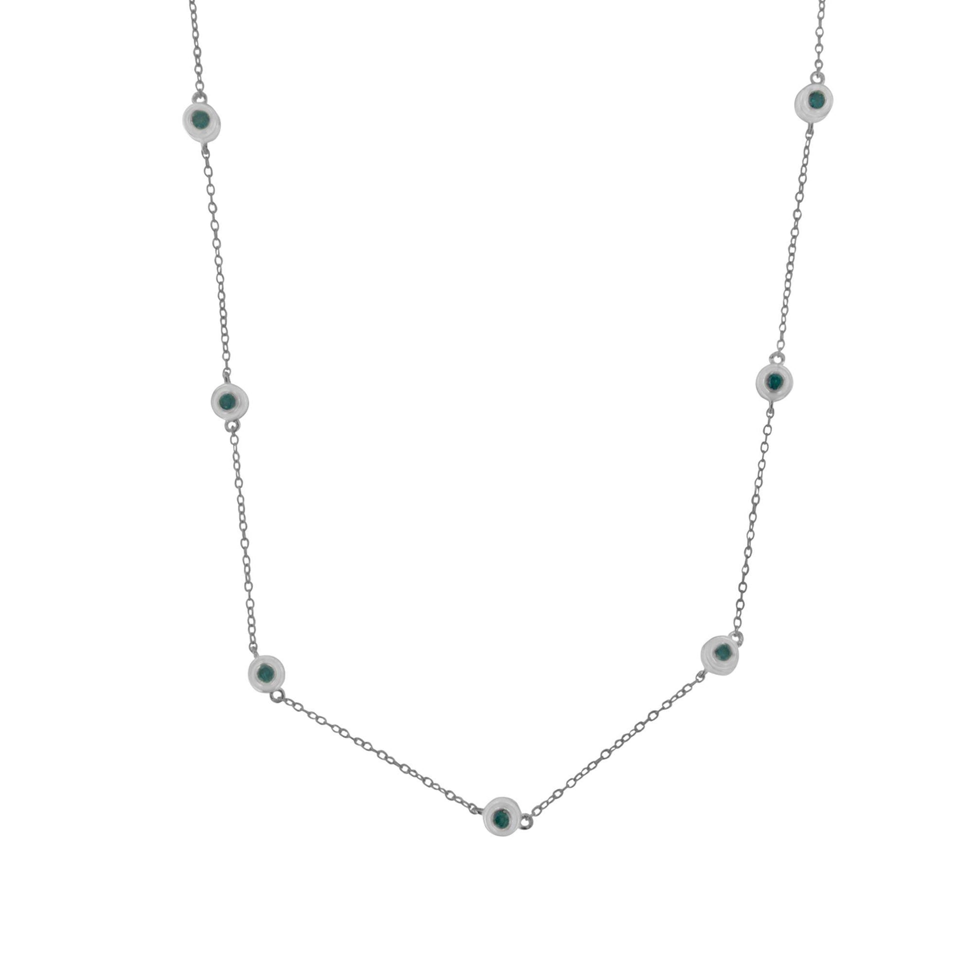 Front-facing close-up of a white metal necklace with evenly spaced blue round gemstones in bezel settings along a delicate chain.