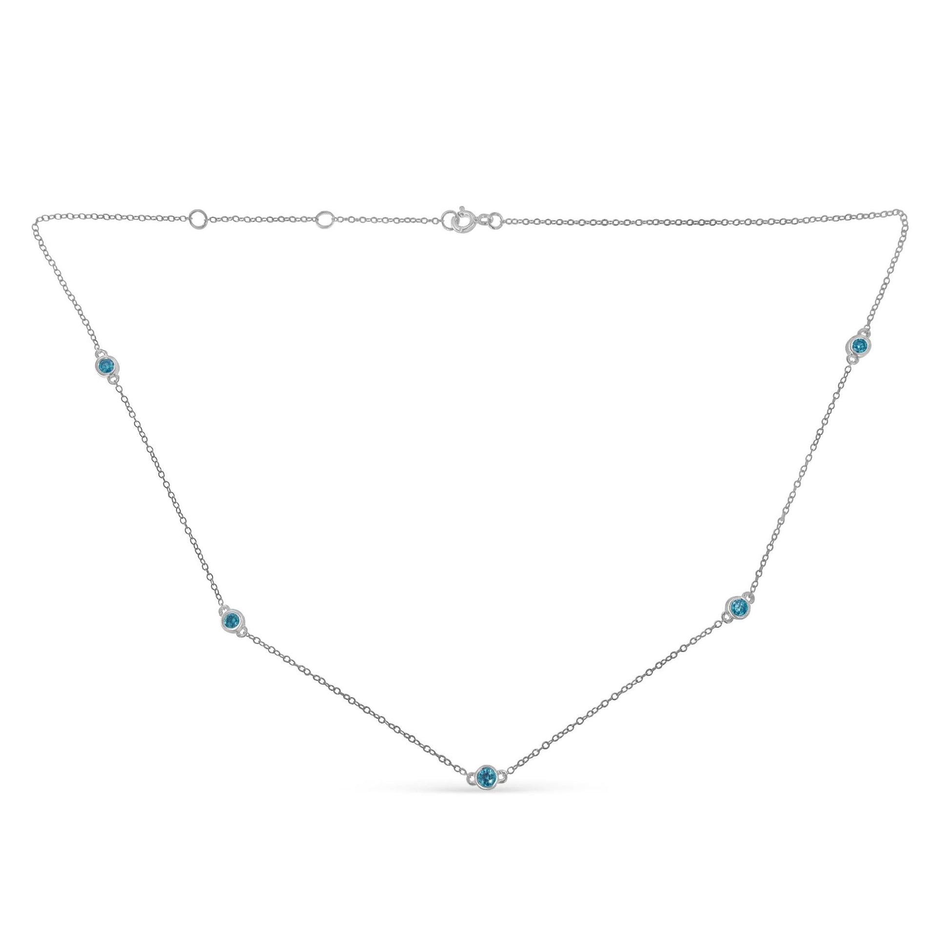 White necklace with round blue gemstones set in bezels along the chain, shown from a flat front angle.