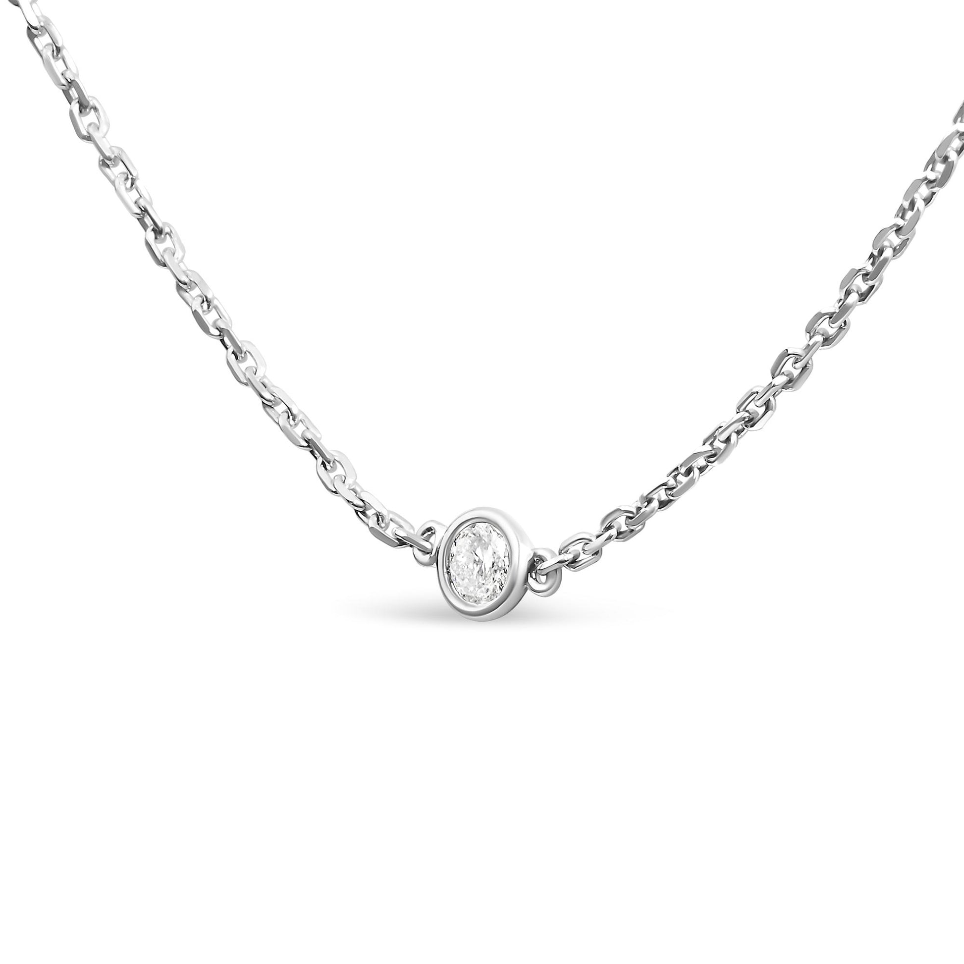 Close-up front angle of a white metal necklace with a round white gemstone in a bezel setting at the center.