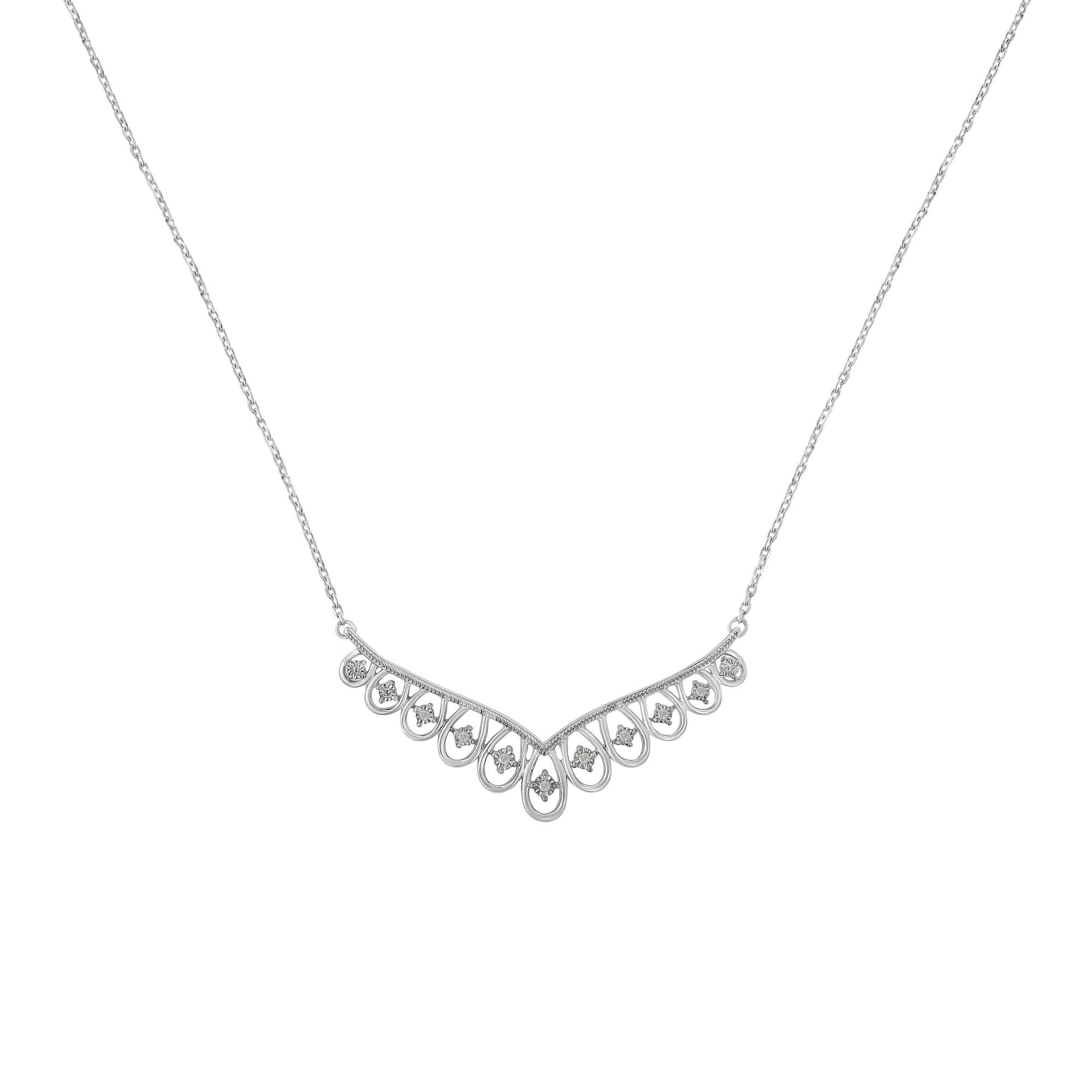 Front-facing view of a white metal necklace with a V-shaped pendant featuring multiple round white gemstones set in a miracle setting.