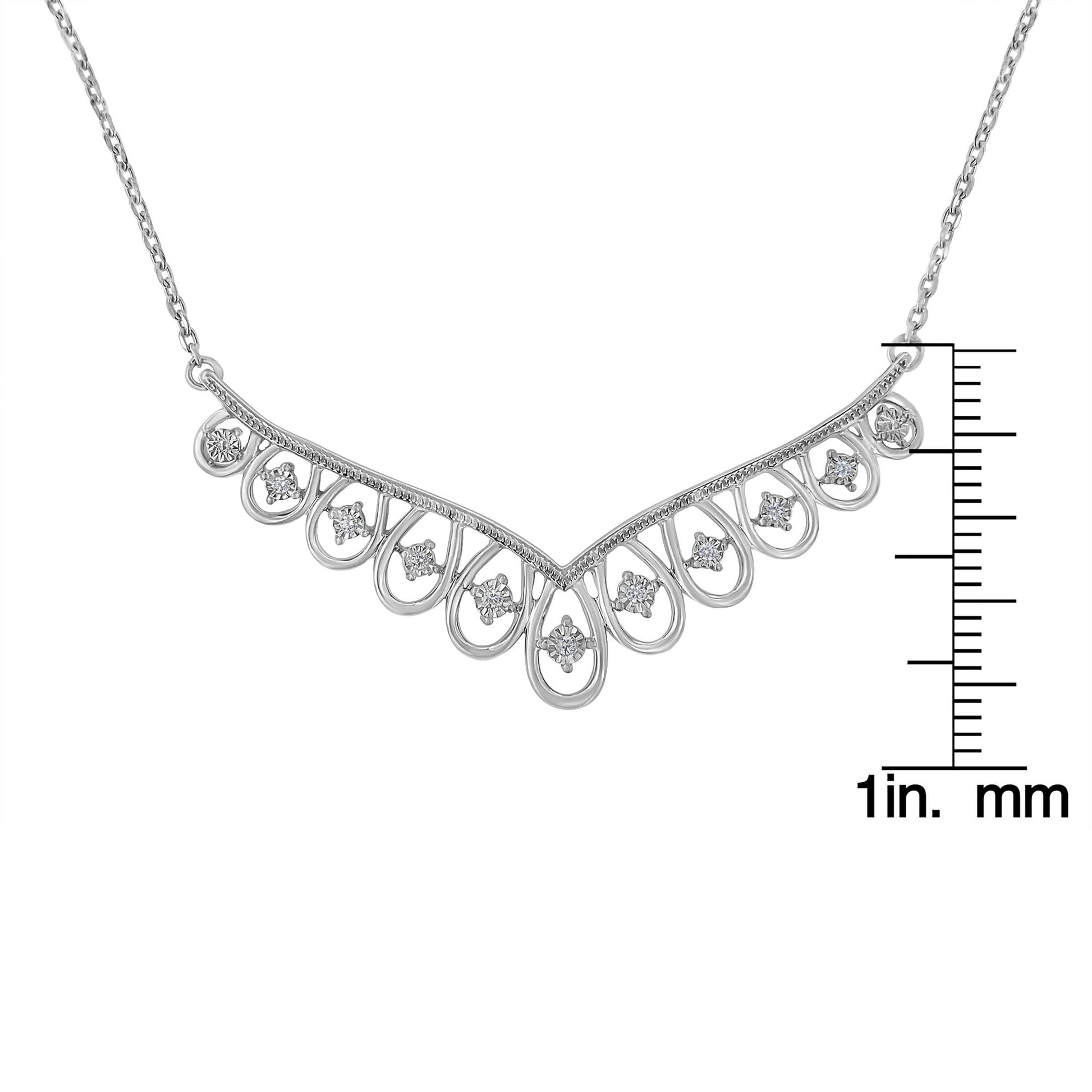 Front angle of white metal necklace featuring a V-shaped design with loop accents, each set with a round white gemstone; necklace is displayed with a ruler for size reference.