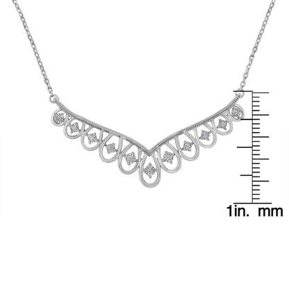 Front angle of white metal necklace featuring a V-shaped design with loop accents, each set with a round white gemstone; necklace is displayed with a ruler for size reference.