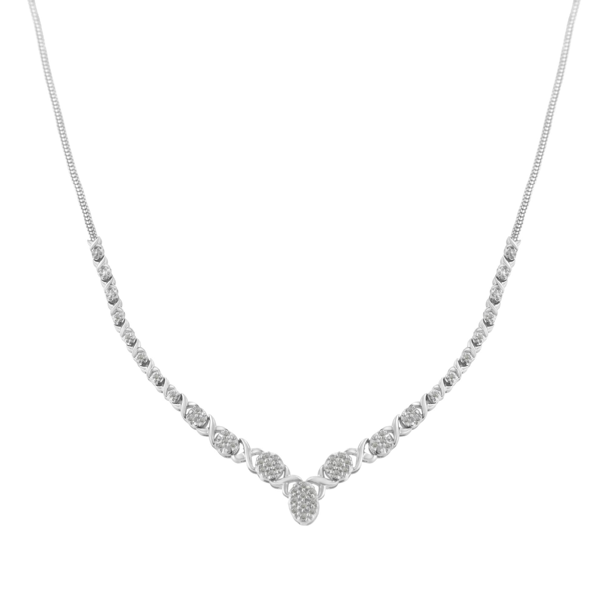 Front-facing shot of a white metal necklace with round white gemstones in prong settings arranged symmetrically along the chain, forming a gentle V shape at the center.