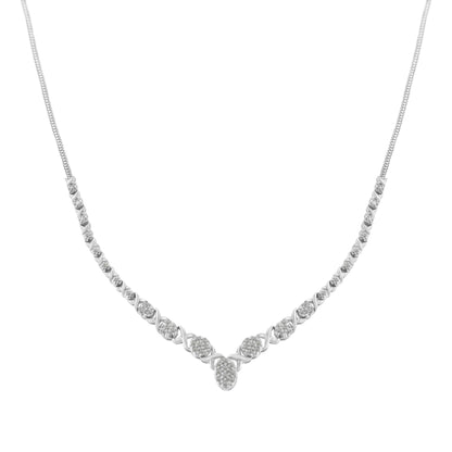 Front-facing shot of a white metal necklace with round white gemstones in prong settings arranged symmetrically along the chain, forming a gentle V shape at the center.