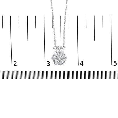Close-up front view of a white metal necklace with a flower-shaped pendant featuring multiple round white gemstones set in prong settings, displayed on a ruler for size reference.