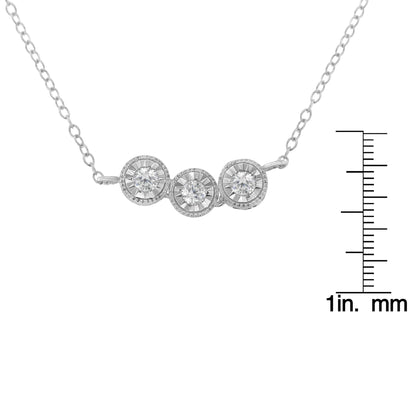 Close-up front-facing view of a white metal necklace with three round white gemstones in miracle settings, shown with a ruler for size reference.