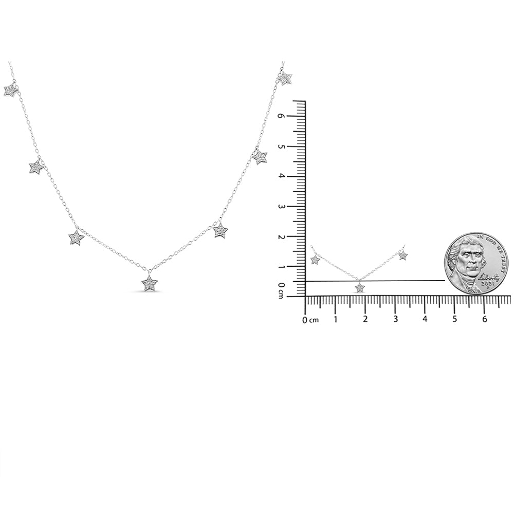 Close-up front view of a white metal necklace featuring multiple star-shaped pendants with round white gemstones in prong settings, shown next to rulers and a coin for size reference.