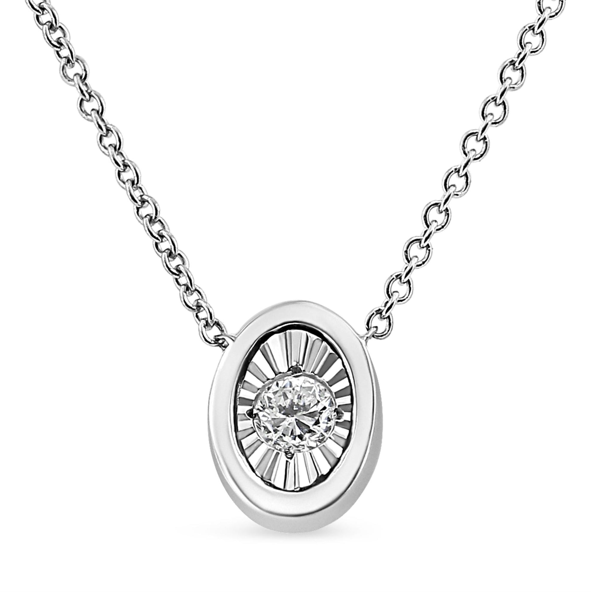 Front-facing shot of a white metal necklace with a circular pendant featuring a round white gemstone in a miracle setting.