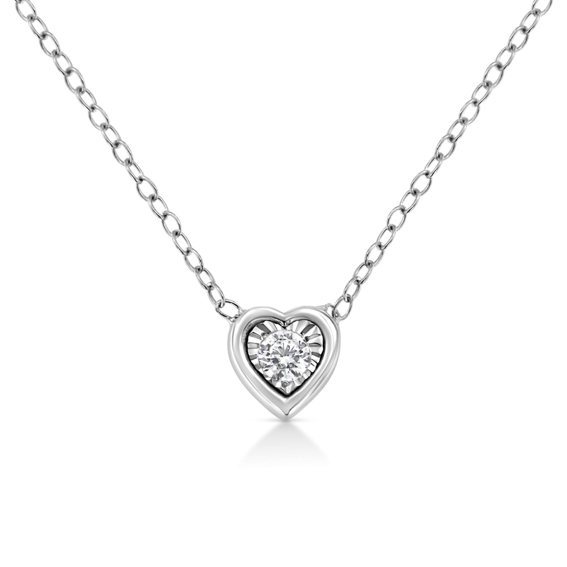 Close-up front view of a white metal heart-shaped necklace with a round white gemstone in a miracle setting at its center.