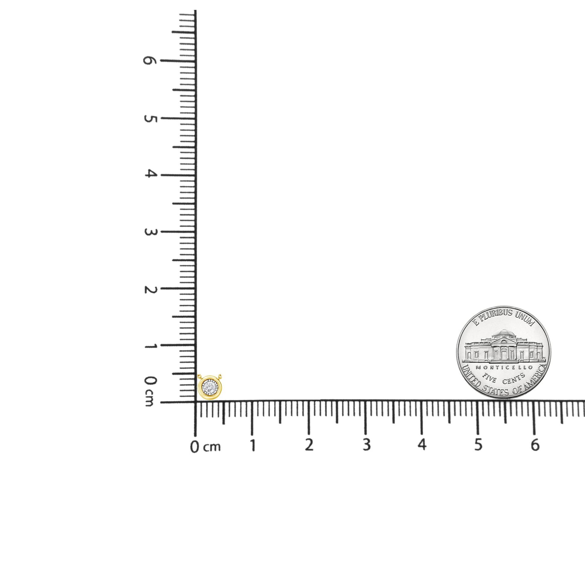 Close-up front angle of a yellow necklace pendant with one round brownish gemstone in miracle setting, placed on a ruler for size reference.