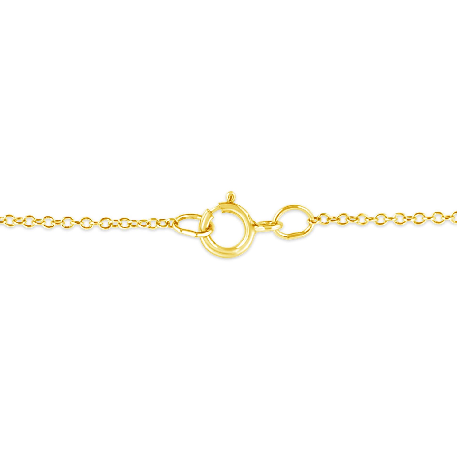 Close-up image of a yellow metal necklace clasp and chain links, shot from the front.