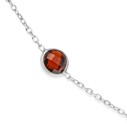 Close-up angled shot of a white metal necklace chain featuring a round red gemstone in a bezel setting.