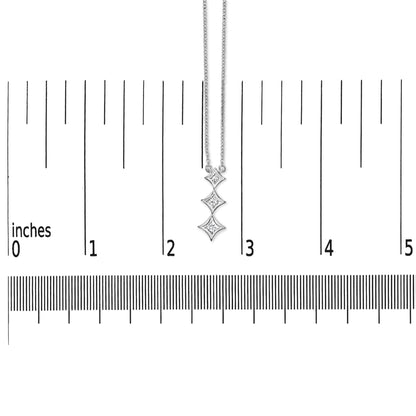 Front view of a white necklace with three princess-shaped white gemstones in bezel settings, shown hanging vertically on a ruler for size reference.