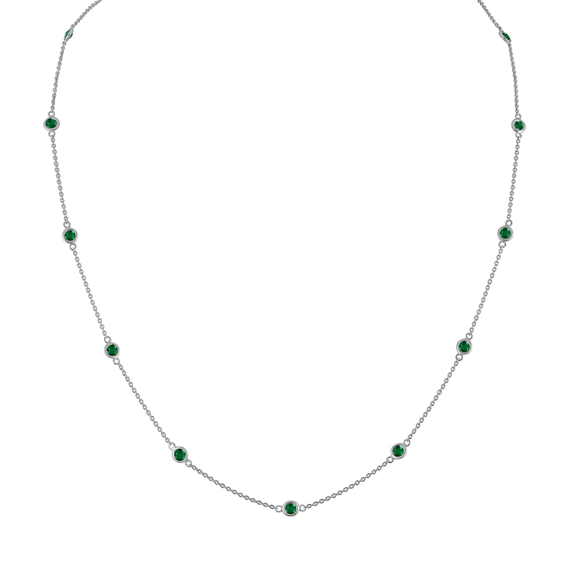 Front view of a white metal necklace with evenly spaced round green gemstones in bezel settings along a thin chain.