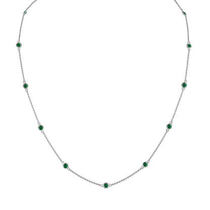 Front view of a white metal necklace with evenly spaced round green gemstones in bezel settings along a thin chain.