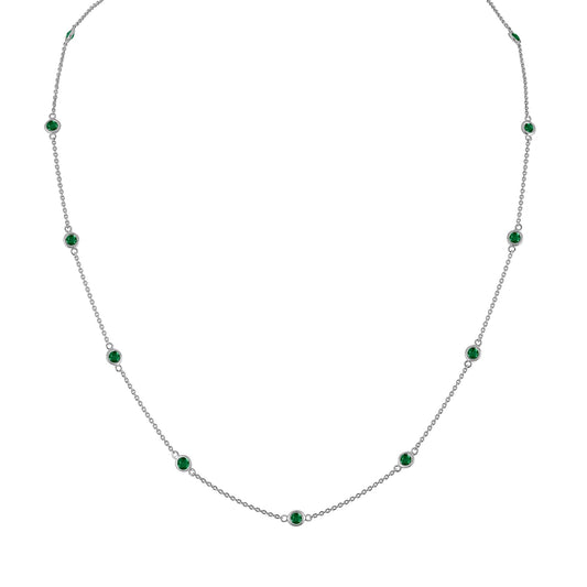 Front view of a white metal necklace with evenly spaced round green gemstones in bezel settings along a thin chain.