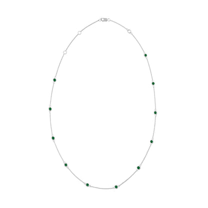 White necklace with bezel-set round green gemstones evenly spaced along the chain, shown against a white background from a top-down angle.