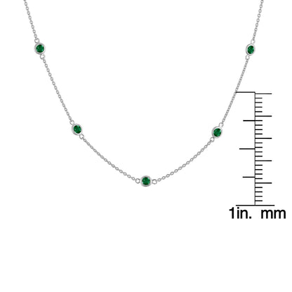 Front view of a white metal necklace with round bezel-set green gemstones, displayed with a ruler for size reference.