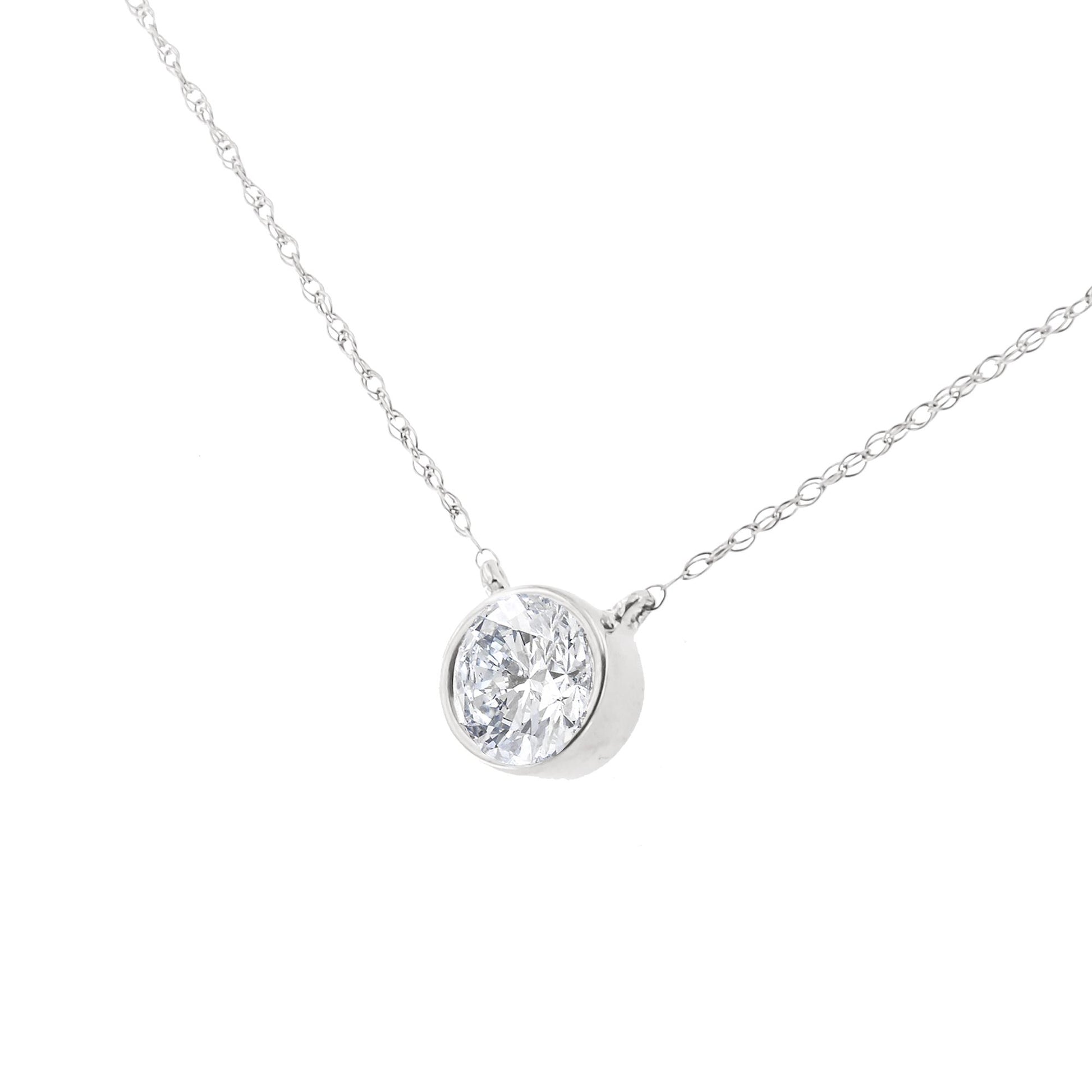 Close-up front angle of a white metal necklace with a single round white gemstone in a bezel setting.