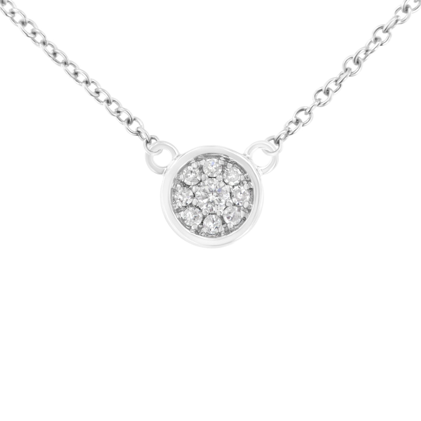Close-up front view of a white necklace with a round pendant featuring a cluster of white round gemstones in prong settings, attached to a fine chain.