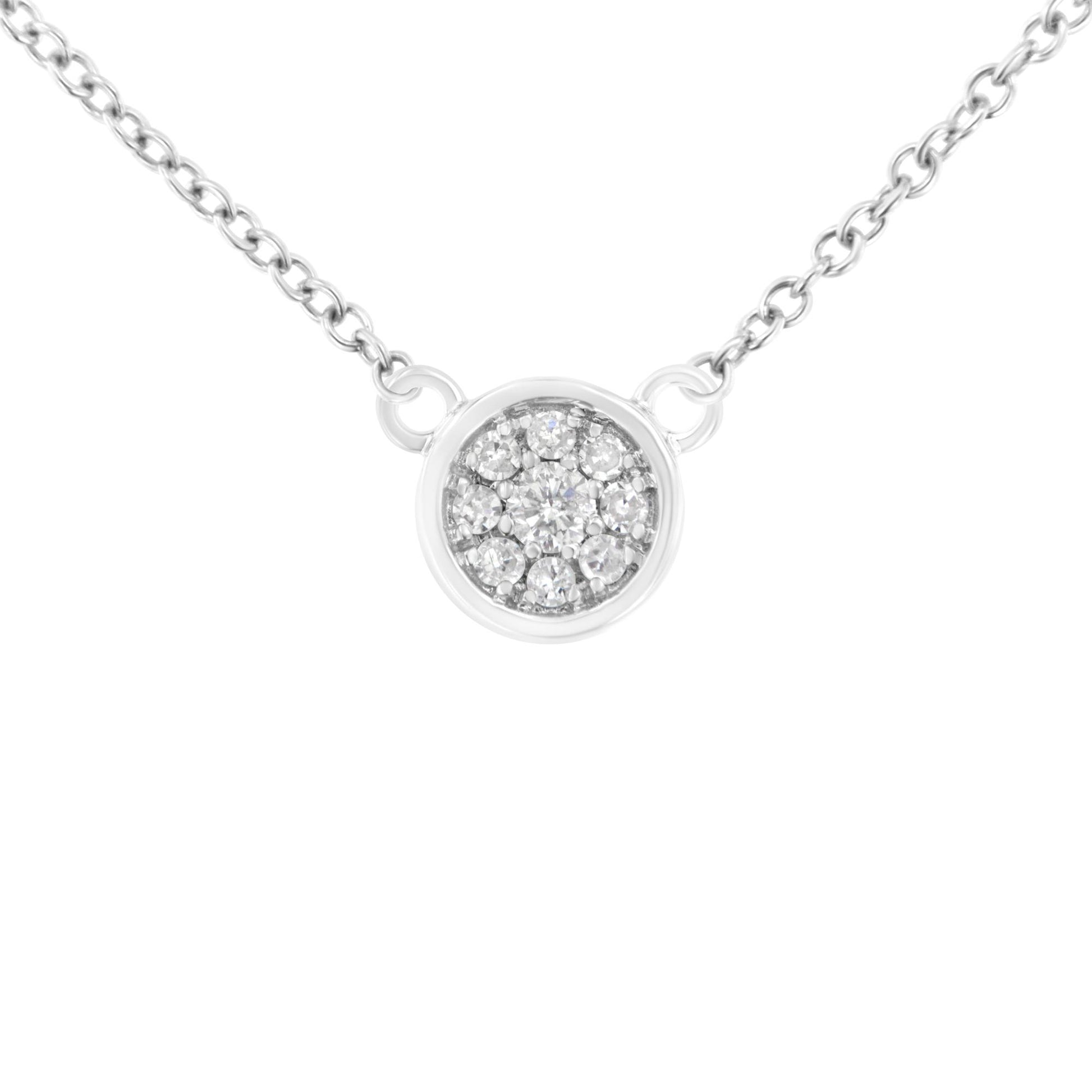 Close-up front view of a white necklace with a round pendant featuring a cluster of white round gemstones in prong settings, attached to a fine chain.