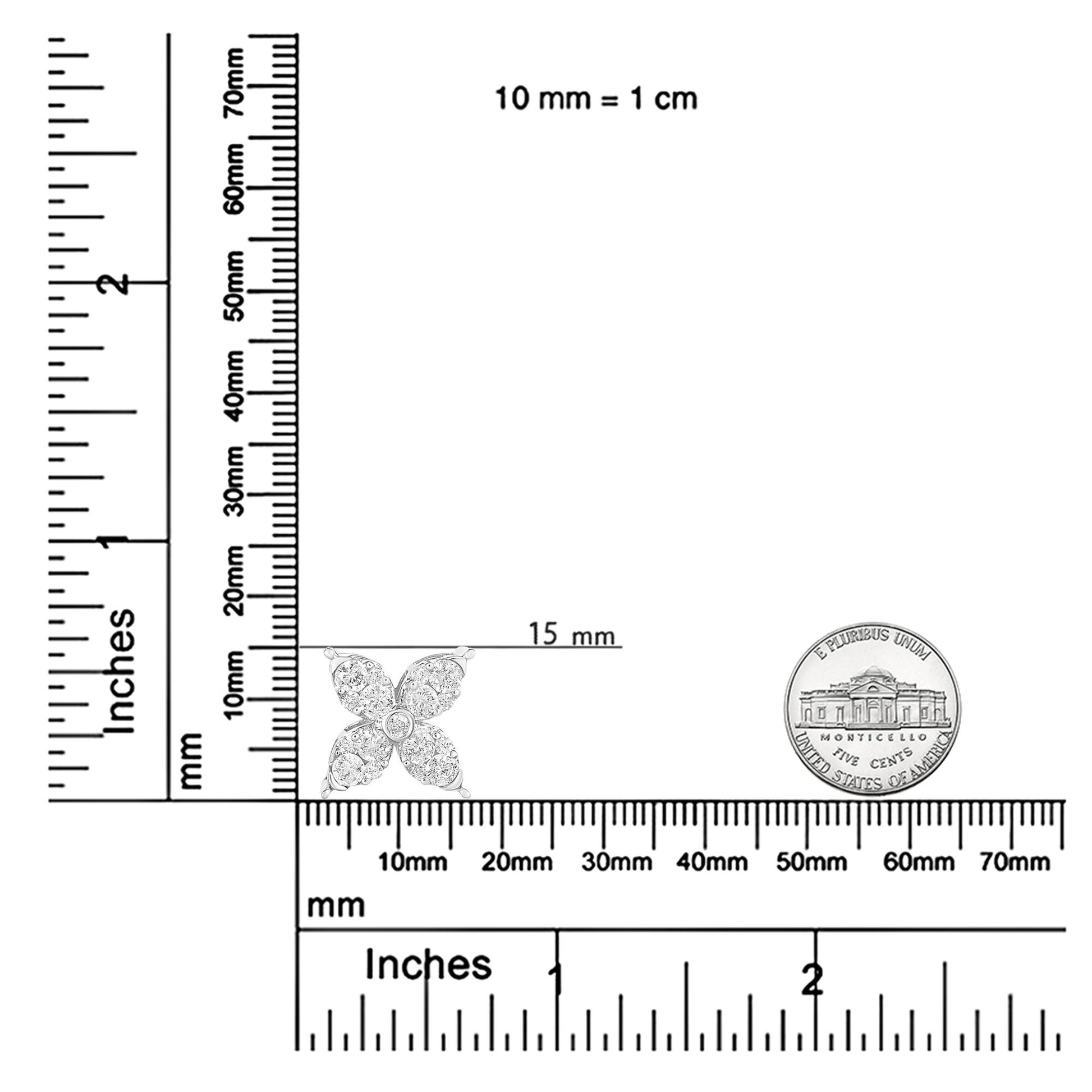 White metal necklace pendant with four petal-like shapes, each paved with round white gemstones, set in prongs; pendant shown on rulers and next to a coin for size reference, front angle view.
