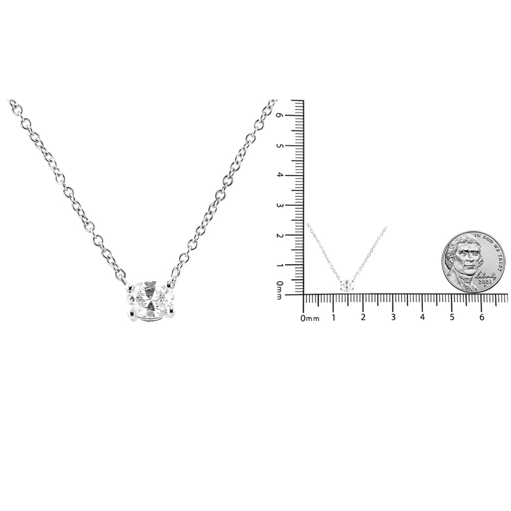 Close-up front view of a white metal necklace with an oval-shaped white gemstone in a four-prong setting, shown next to a ruler and a coin for size reference.