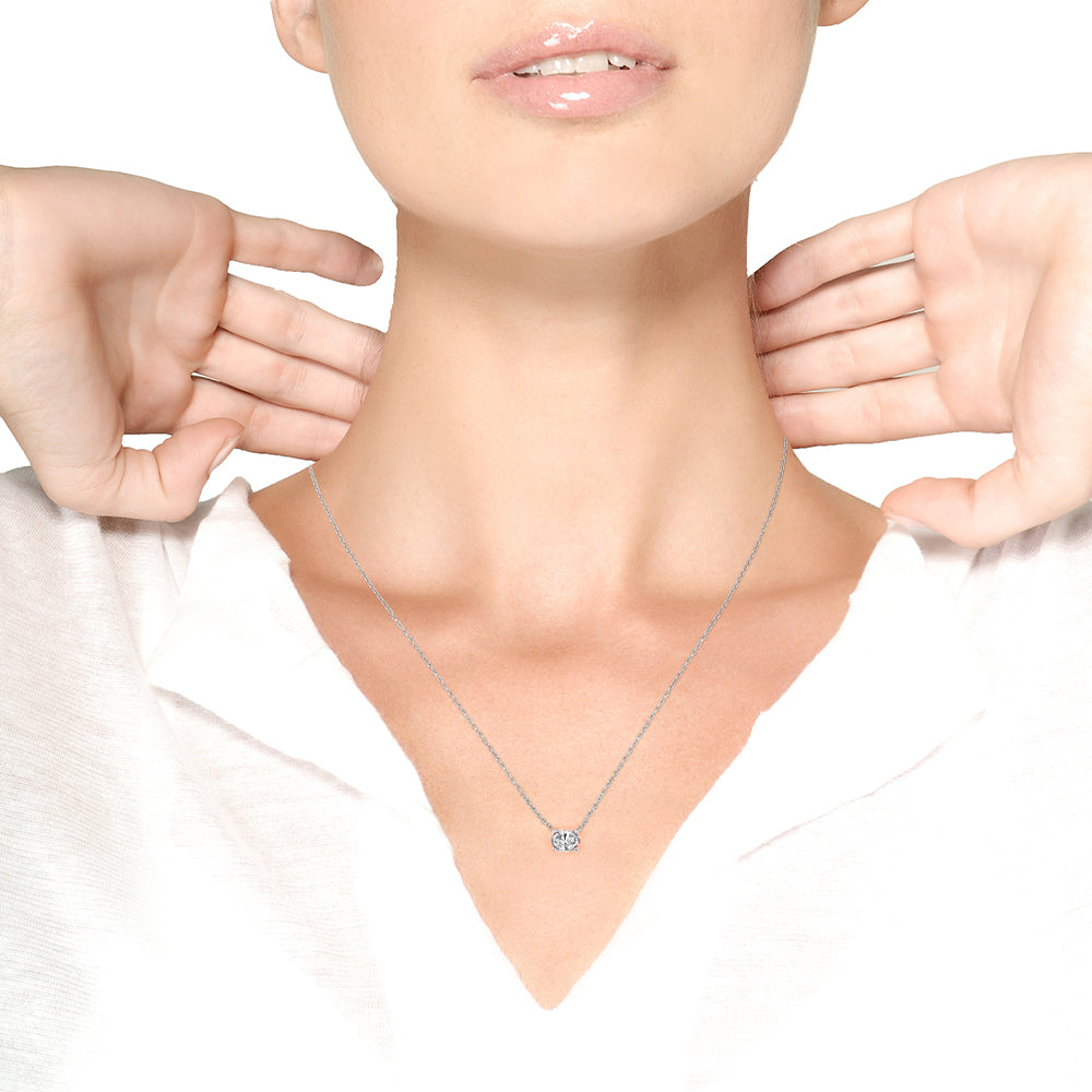 White metal necklace with an oval pink gemstone in a four-prong setting, shown on a model from a front angle.