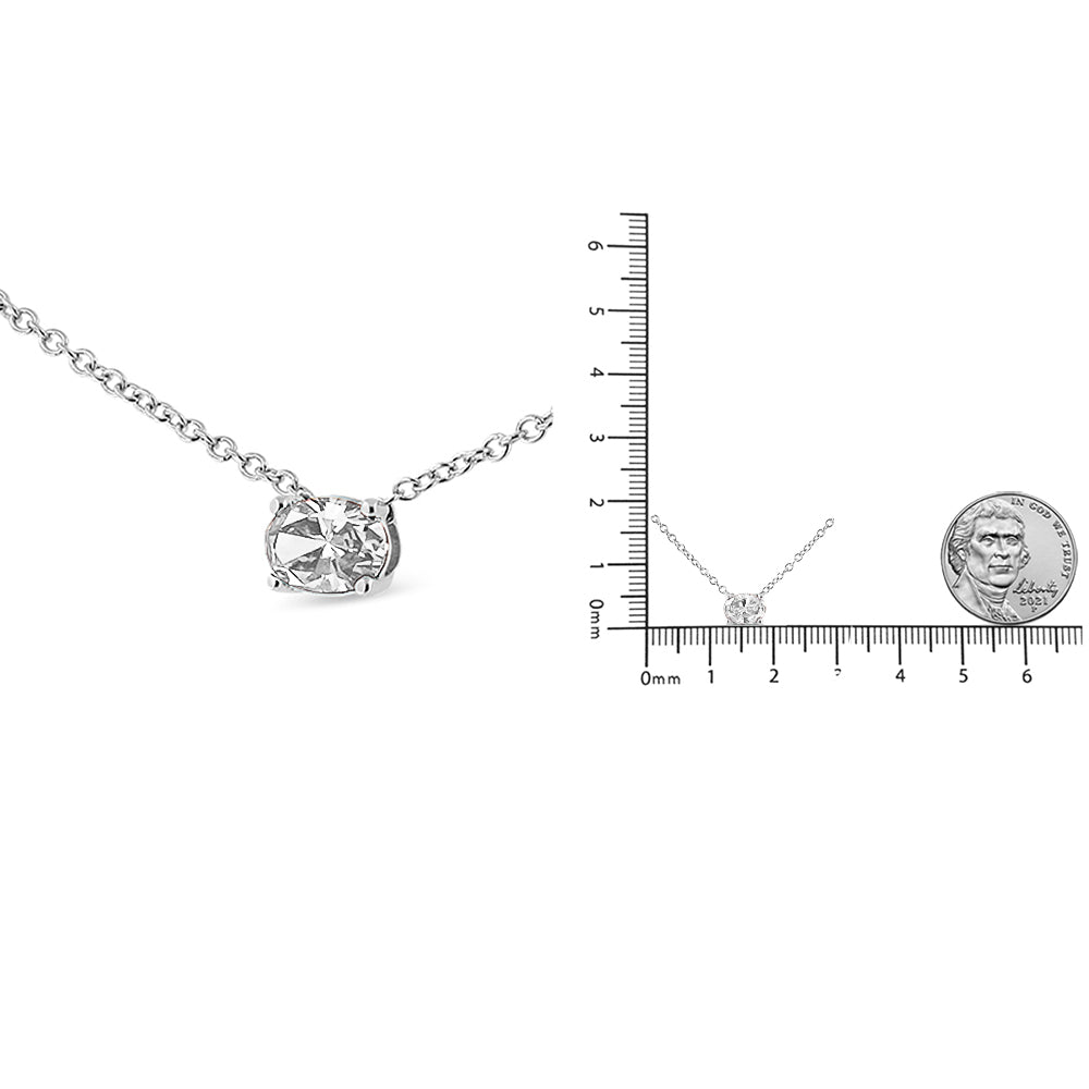 Close-up front angle of white metal necklace with single oval-shaped white gemstone in prong setting, also shown next to ruler for size reference.