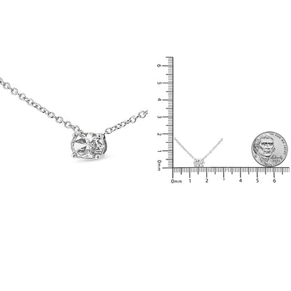 Close-up front angle of white metal necklace with single oval-shaped white gemstone in prong setting, also shown next to ruler for size reference.