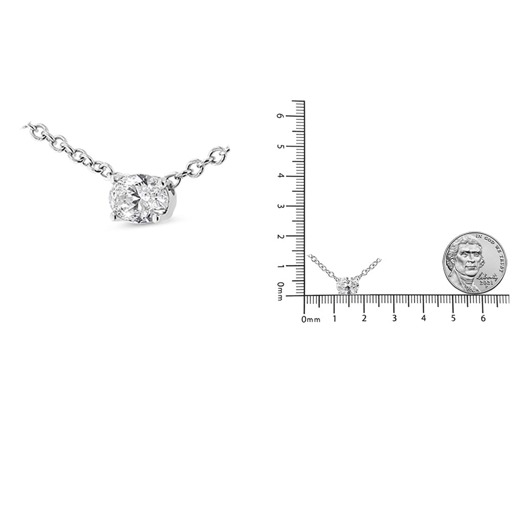 White metal necklace with an oval-shaped white gemstone in a four-prong setting, shown front-facing and next to a ruler and coin for size reference.