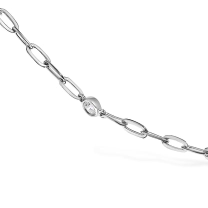 Close-up angled shot of a white metal necklace featuring a chain link design with a single round white gemstone in a bezel setting.