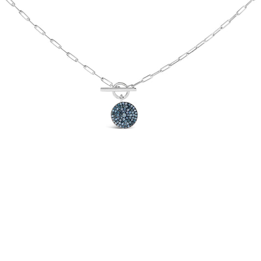 Front view of a white metal necklace with a toggle clasp and a round pendant encrusted with multiple blue round gemstones.