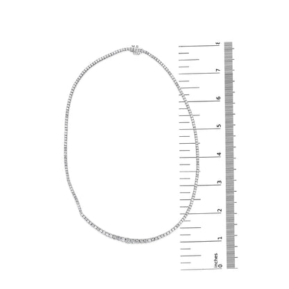 White metal necklace with round white gemstones in four-prong settings, laid flat next to a ruler for size reference, top-down angle.