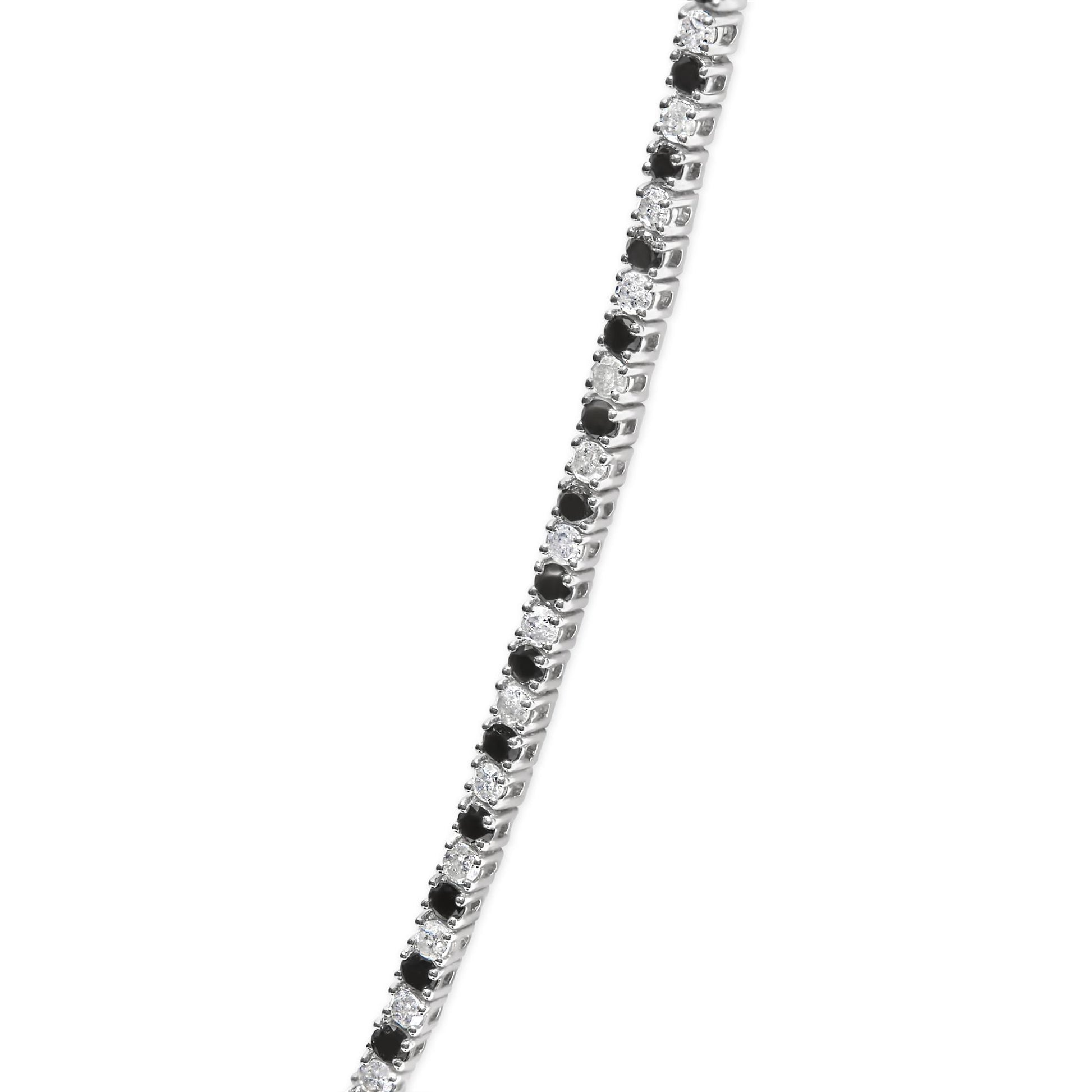 Close-up front angle of a white metal necklace featuring alternating round white and black gemstones in 4-prong settings.