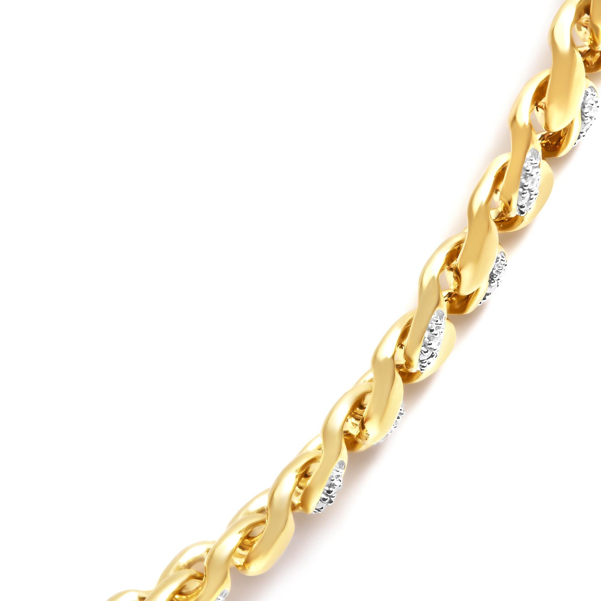 Close-up diagonal view of a yellow metal necklace chain with alternating links set with white round gemstones in prong settings.