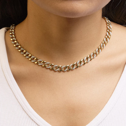 Close-up front view of a yellow metal necklace with alternating plain and white gemstone-studded links, worn on a model's neck.