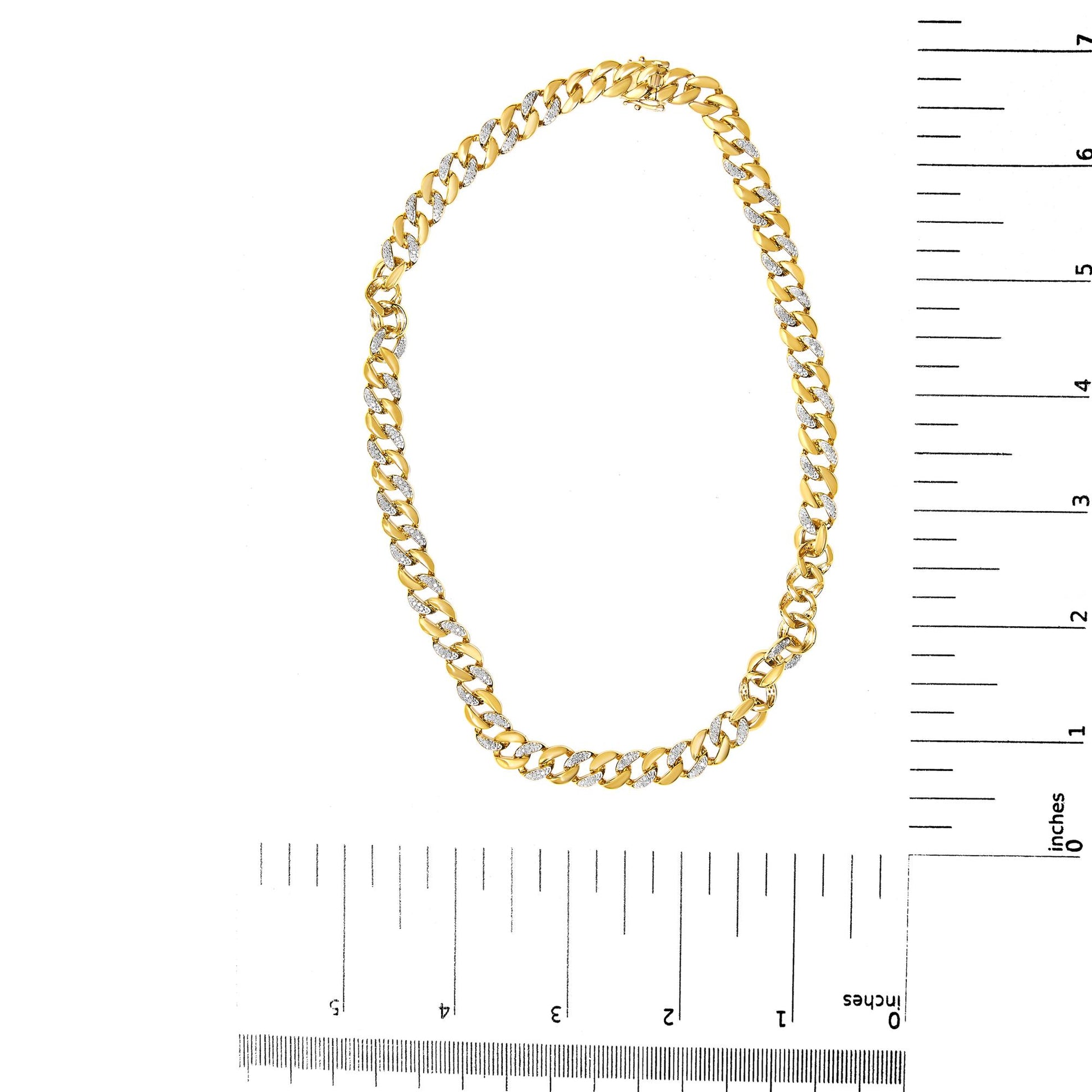 Yellow metal chain necklace with alternating links featuring white round gemstones in prong settings, displayed flat next to a ruler for size reference, photographed from above.