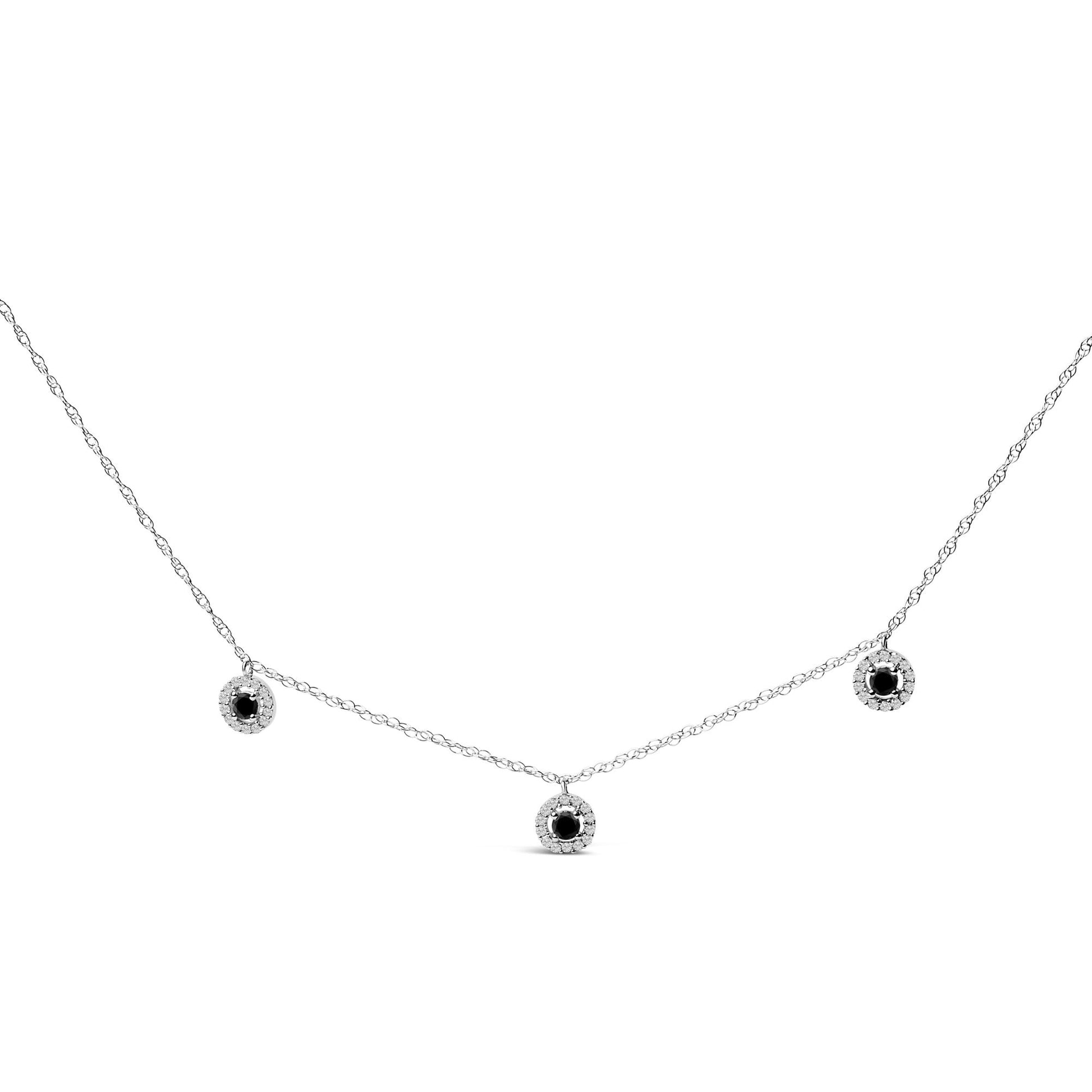 White necklace with three round black center gemstones surrounded by white gemstones in prong settings, shown in a front flat lay angle on a white background.