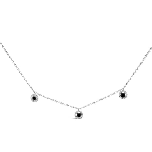 White necklace with three round black center gemstones surrounded by white gemstones in prong settings, shown in a front flat lay angle on a white background.